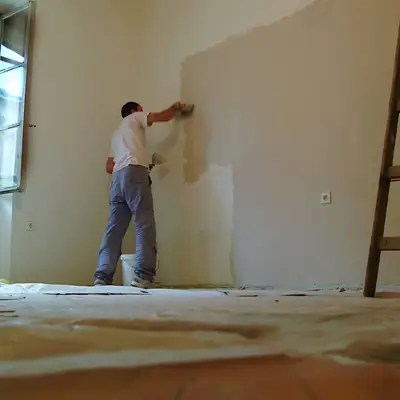 Decorator painting an interior wall